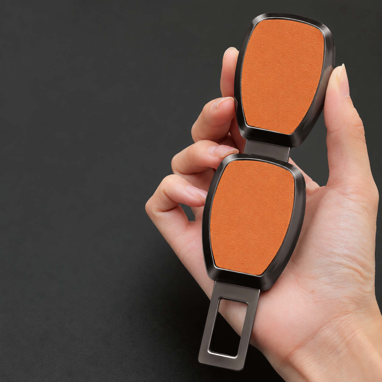 Holding two orange seat belt alarm stoppers in hand Holding two orange seat belt alarm stoppers in hand